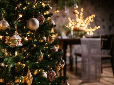 close up of a decorated Christmas tree with dining room in background