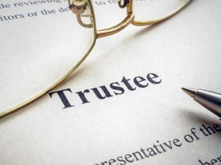 Image of a document titled Trustee with a pair of glasses visible