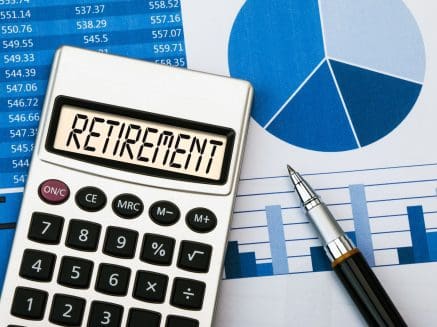 Image of graphs denoting savings and calculator with display showing the word retirement