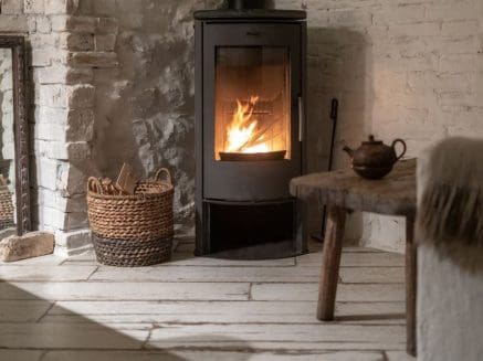 Image of a woodburning stove in a sitting room with wooden floor