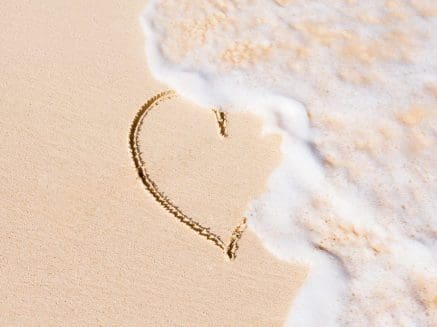image of a heart drawn on a beach with tide washing over it to denote relationship issues